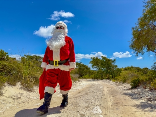 Father Christmas walking down a country track through coastal bushland - Australian Stock Image