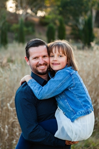 Father giving young daughter a hug - Australian Stock Image