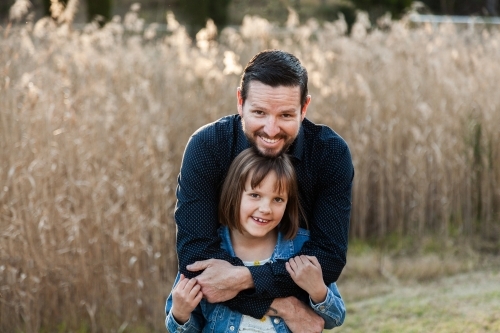 Father giving young daughter a hug - Australian Stock Image