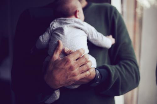 Father holding baby on chest - Australian Stock Image