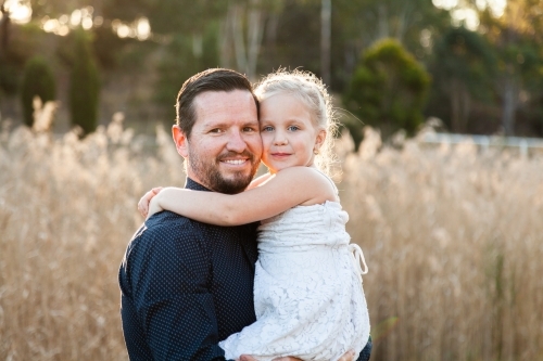 Father holding his little girl in his arms - Australian Stock Image