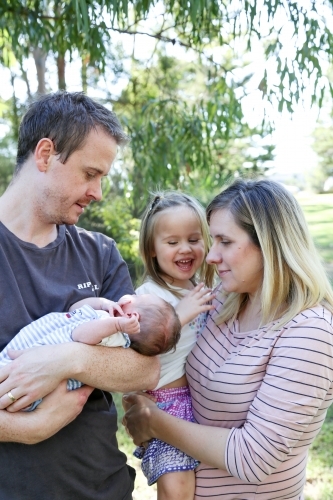 Father holding new baby, with sister and mother - Australian Stock Image