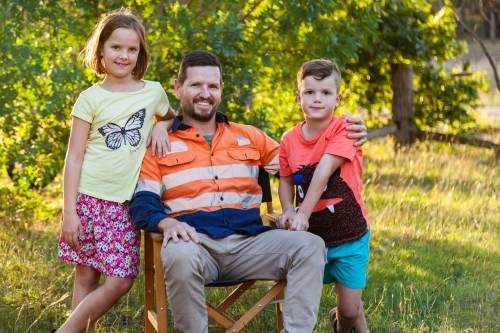 Father relaxing after work with his daughter and son - Australian Stock Image