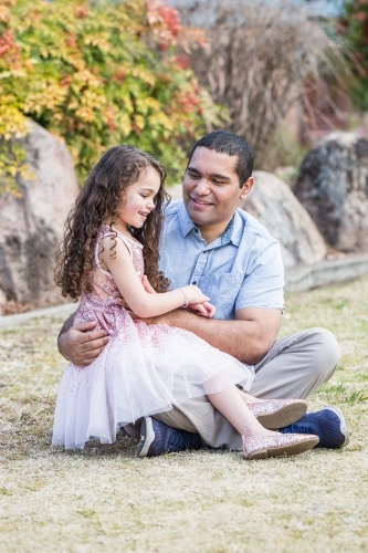 Father sitting talking with mixed race aboriginal caucasian daughter - Australian Stock Image