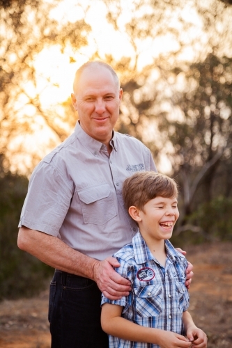 Father smiling and son laughing in orange sunset light