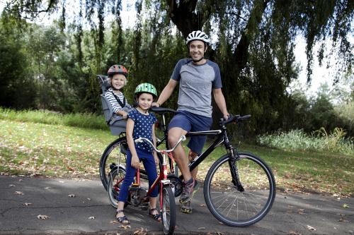 Father with two kids on a family bike ride - Australian Stock Image