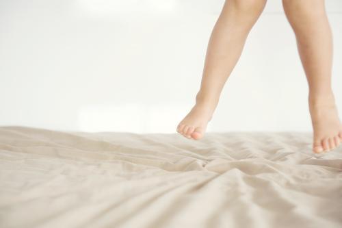 Feet of Child Jumping On The Bed