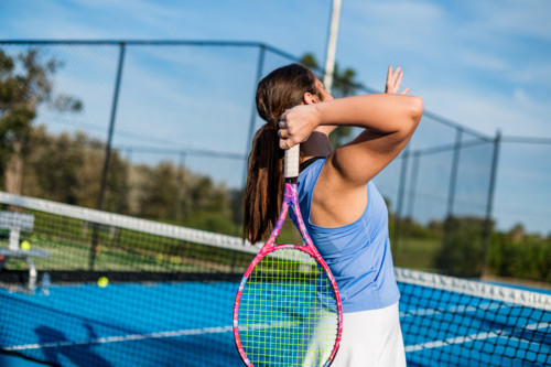 Female athlete focuses on a smash during a tennis game - Australian Stock Image