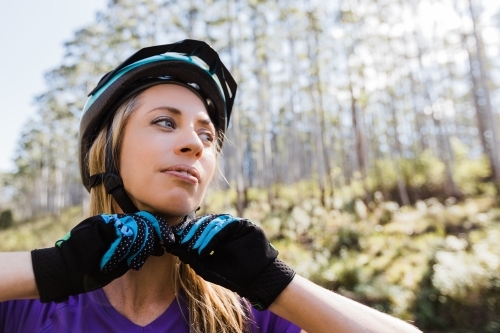 Female biker putting her helmet on