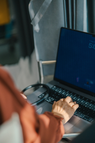 Female doctor typing on the laptop for documentation - Australian Stock Image