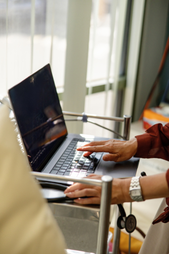 Female doctor typing on the laptop for documentation - Australian Stock Image