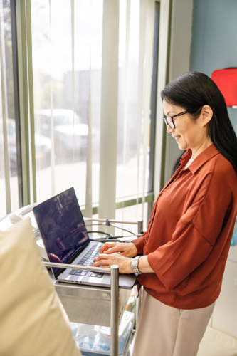 Female doctor typing on the laptop for documentation - Australian Stock Image