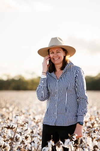 Female farmer in a cotton crop using an iphone - Australian Stock Image
