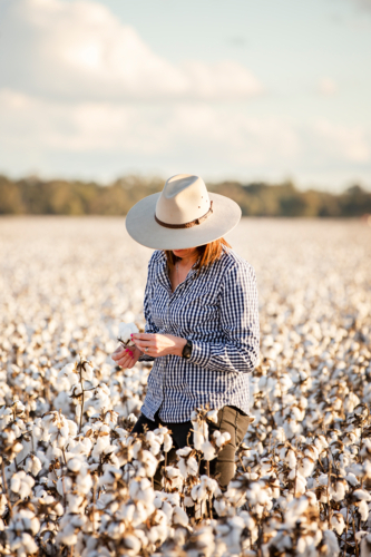 Female farmer looking at a cotton crop - Australian Stock Image