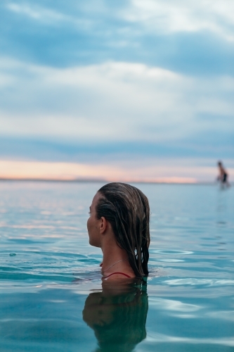 Female in ocean at sunset - Australian Stock Image