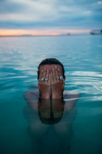 Female in ocean at sunset - Australian Stock Image