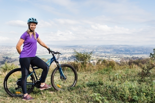 Female mountain bike rider smiling with bike
