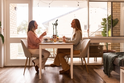 Female same sex couple eating a meal together at home - Australian Stock Image