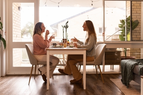 Female same sex couple eating a meal together at home - Australian Stock Image