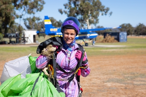 female skydiver hauling parachute back to clubhouse after a successful jump