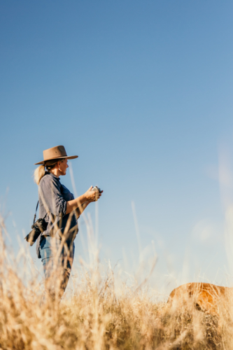 Female standing holding drone controller looking to sky - Australian Stock Image