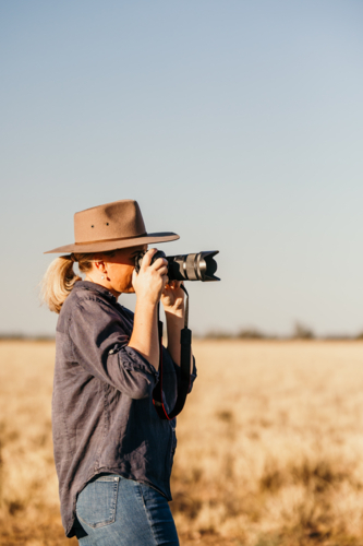 Female standing with camera on farm - Australian Stock Image
