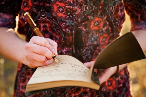 Female writing in journal with fountain pen - Australian Stock Image