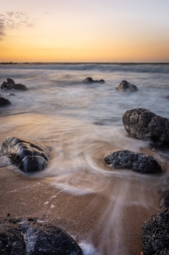 First Light on a Rocky Australian Beach at High Tide - Australian Stock Image
