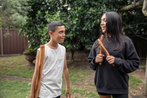 First Nations teenagers holding Indigenous instruments - Australian Stock Image