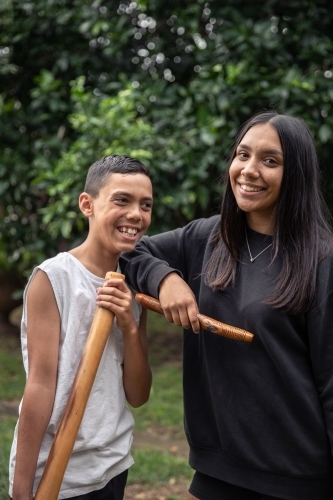 First Nations teenagers holding Indigenous instruments - Australian Stock Image