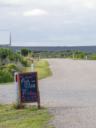 Fish and chip sign by side of quiet street - Australian Stock Image