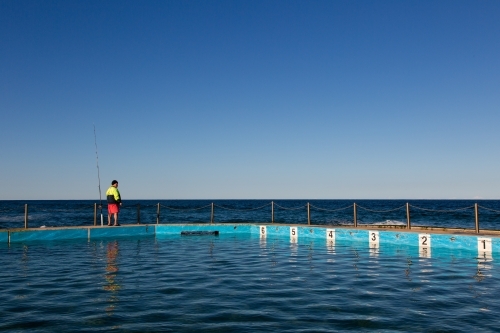 Fisherman at ocean pool - Australian Stock Image