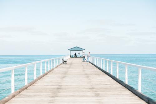 Fisherman on a jetty overlooking the ocean - Australian Stock Image