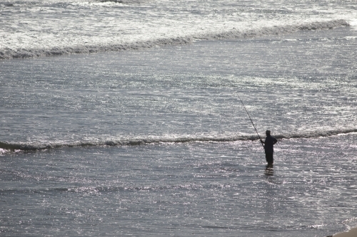 Fisherman standing in water - Australian Stock Image
