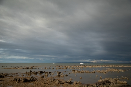 Fishing boats in the bay off Redcliffe in Brisbane's northern suburbs on overcast day - Australian Stock Image
