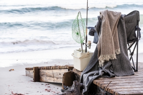 Fishing supplies on a fold-out chair on the beach - Australian Stock Image