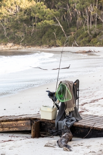 Fishing supplies on a fold-out chair on the beach - Australian Stock Image