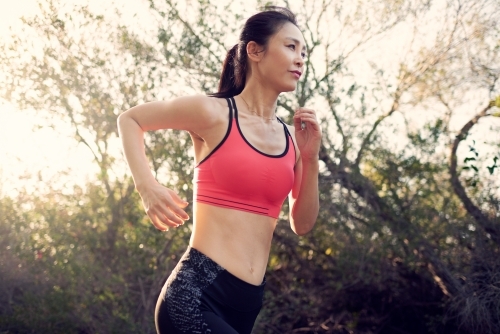 Fit Asian woman running for morning exercise - Australian Stock Image