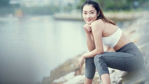 Happy Asian woman resting after morning workout - Australian Stock Image