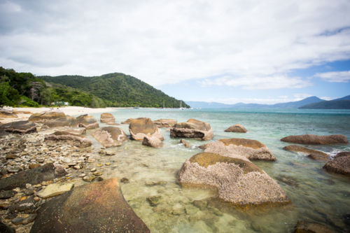 Fitzroy Island main beach area with rocks on a cool winter's day in Queensland, Australia - Australian Stock Image