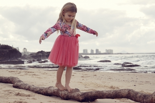 Five year old balancing on log - Australian Stock Image