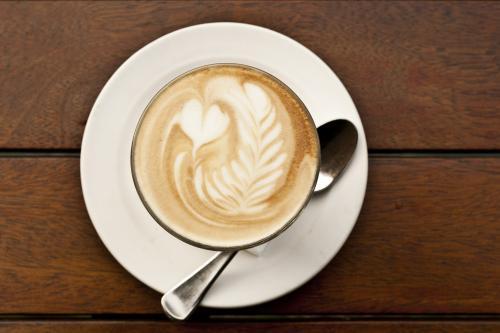 Flat white coffee with latte art featuring hearts and rosetta - Australian Stock Image