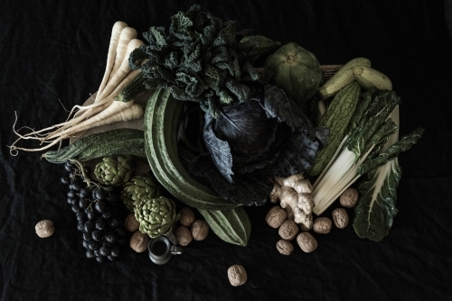 flemish style flat lay of fruit and vegetables with dark background