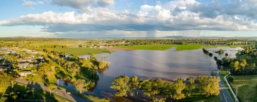 Flooding farm paddocks and distant rain and storm clouds - Australian Stock Image