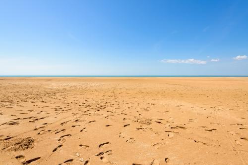 Footprints all over a beach at low tide - Australian Stock Image