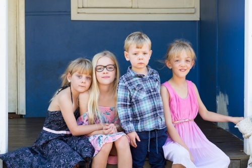 Four little kids sitting on step