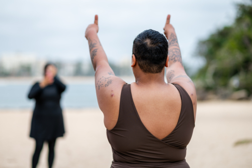 French Islander woman giving two thumbs up towards friend in burkini - Australian Stock Image
