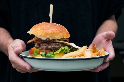 Fresh cooked burger and chips ready to eat - Australian Stock Image