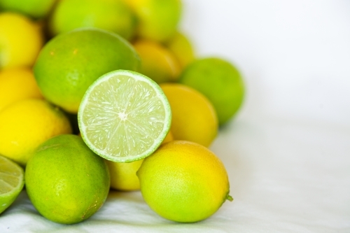 Fresh lime fruit harvest on white background, sliced open - Australian Stock Image
