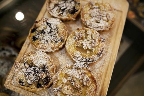 Freshly made tarts on display at bakery cafe - Australian Stock Image